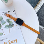 Double-sided genuine leather apple watch band on a table next to a magazine, showcasing its stylish design.